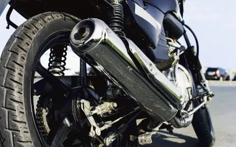 Detalle de la rueda trasera y el escape cromado de una motocicleta. Si te preguntas cuanto cuesta homologar un escape, este podría ser el tuyo.
