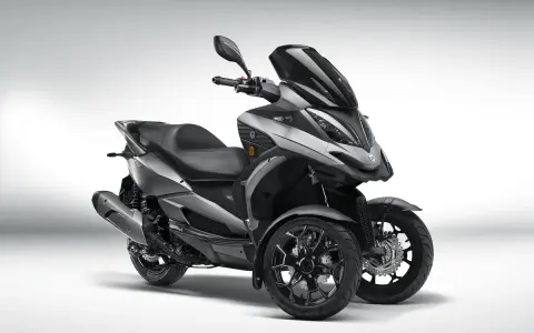 Triciclo gris moderno, estilo deportivo, con tres ruedas. El **Quadro QV3** es un vehículo ágil y seguro, ideal para sortear el tráfico urbano sin **problemas**.