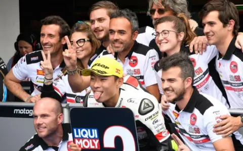 El equipo de Paolo Simoncelli celebra con gestos de victoria.