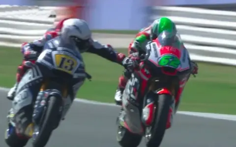 Dos pilotos de MotoGP compiten, uno con el número 13 y el otro con el 62. Romano Fenati, con el 13, intenta adelantar.