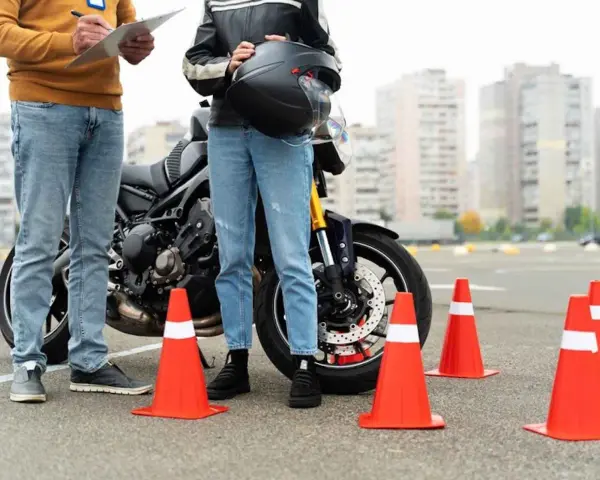 Instructor y alumno junto a moto en circuito de prácticas. Se preguntan: ¿cuánto dura el teórico del A2?