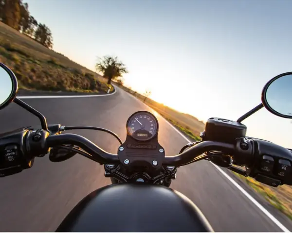 Manillar de moto en carretera al atardecer, listo para el examen de circulación A2.