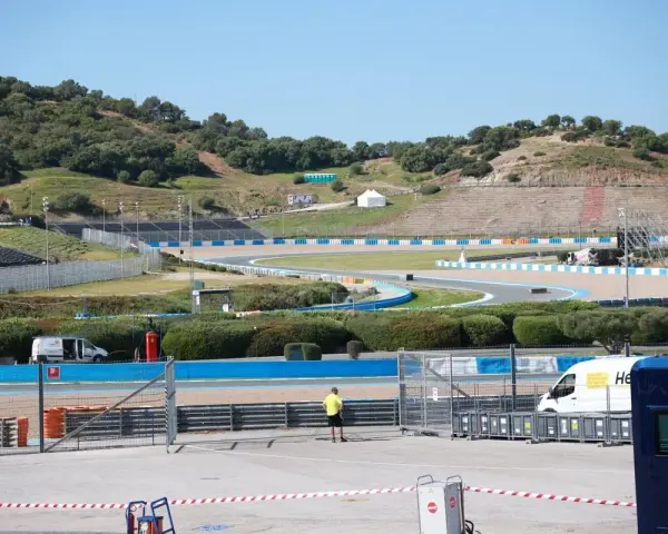 Pista de carreras con gradas y vegetación. Se preparan las instalaciones para la próxima carrera de MotoGP.