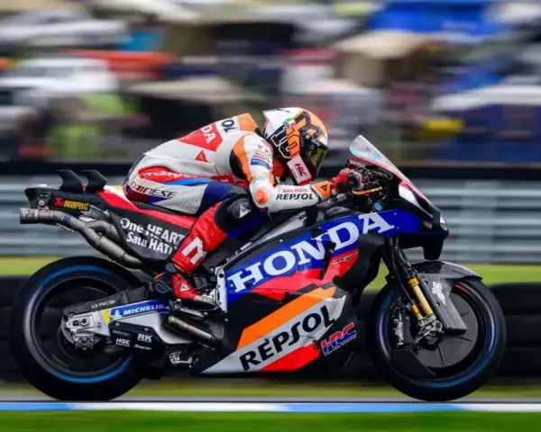 Piloto del Repsol Honda Team en plena carrera, con su moto de competición luciendo los colores icónicos.