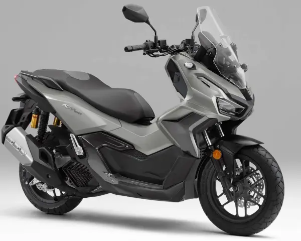 Scooter gris Honda ADV 160 con parabrisas alto y asiento doble.