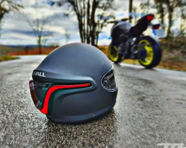 Casco negro mate con luces traseras rojas, listo para la aventura. Los mejores cascos de seguridad para tu moto.