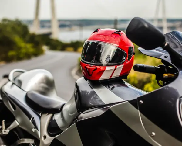 Casco rojo y blanco sobre una moto deportiva. Listo para limpiar interior casco y salir a la carretera.