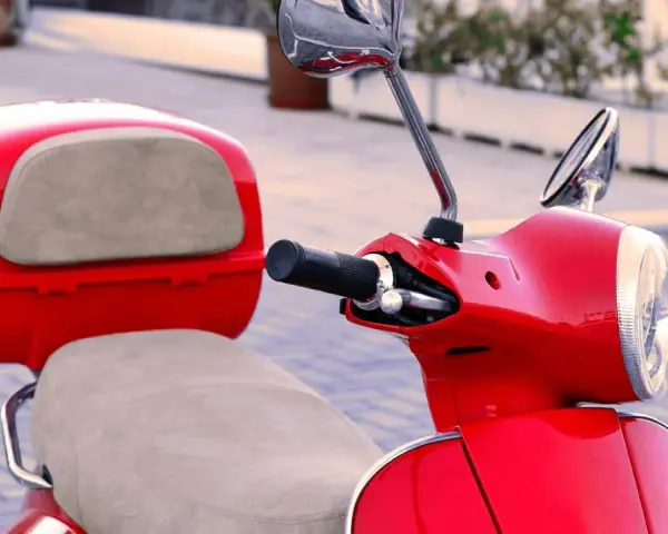 Scooter gran cilindrada rojo brillante, con asiento y maletero a juego. Lista para recorrer la ciudad con estilo.