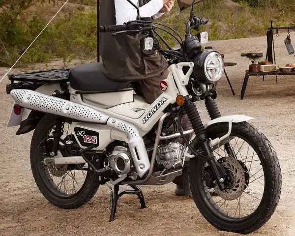 Honda CT 125 lista para la aventura. Su diseño robusto y el color blanco la hacen ideal para explorar caminos rurales o disfrutar de un día de campo.