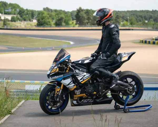 Piloto con talla mono moto listo para competir en circuito.