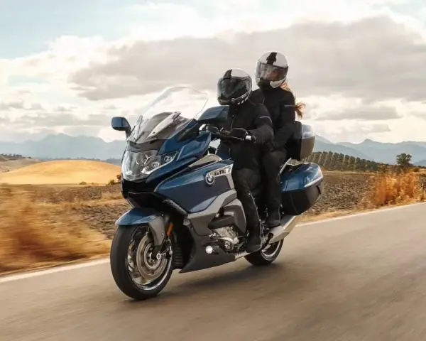 Pareja disfrutando de un viaje en moto cómoda por un paisaje rural.