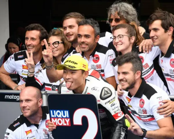 El equipo de Paolo Simoncelli celebra con gestos de victoria.