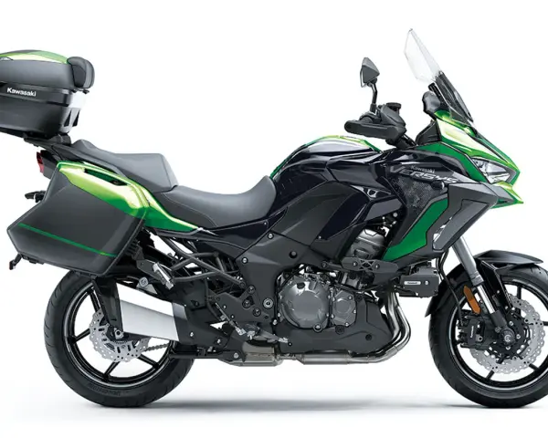 Una moto crossover Kawasaki Versys negra y verde, lista para la aventura con maletas laterales y baúl.