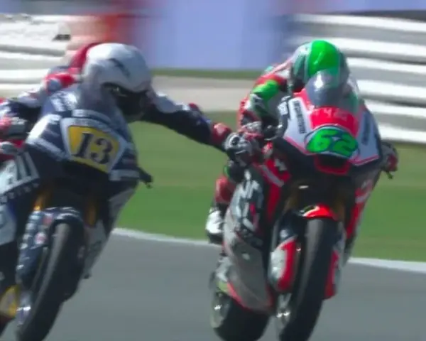 Dos pilotos de MotoGP compiten, uno con el número 13 y el otro con el 62. Romano Fenati, con el 13, intenta adelantar.