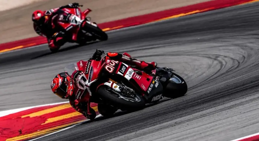 Dos pilotos de superbikes en sus motos rojas toman una curva cerrada. ¡No te pierdas el horario superbikes hoy en Teledeporte!
