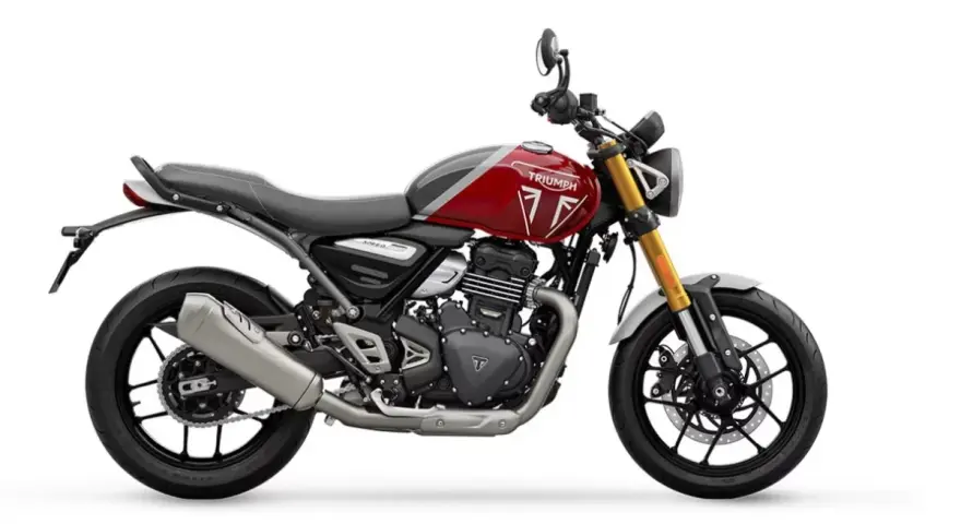Una moto Triumph roja y gris, un ejemplo de motos neo retro, con horquilla dorada y escape plateado, lista para la aventura.