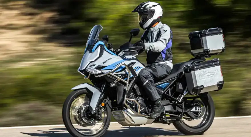 Motociclista con casco blanco y equipo de aventura sobre una moto Zontes, lista para explorar caminos. Motos adventure A2 perfectas para tu próxima travesía.