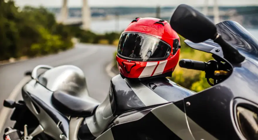 Casco rojo y blanco sobre una moto deportiva. Listo para limpiar interior casco y salir a la carretera.