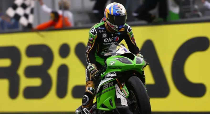 Kenan Sofuoğlu cruza la meta en su Kawasaki Ninja, con la bandera a cuadros ondeando.