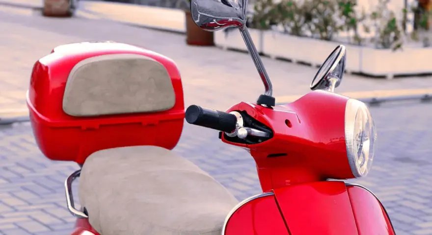 Scooter gran cilindrada rojo brillante, con asiento y maletero a juego. Lista para recorrer la ciudad con estilo.