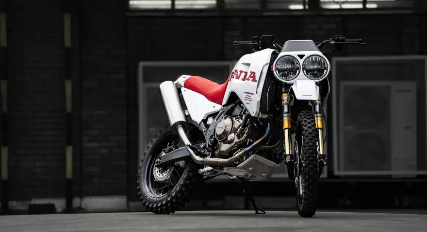 Honda Africa Twin Dakar lista para la aventura. Moto blanca y roja con doble faro y neumáticos todoterreno.