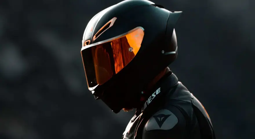 Motociclista con su primer casco de moto, visera naranja reflejando la luz.