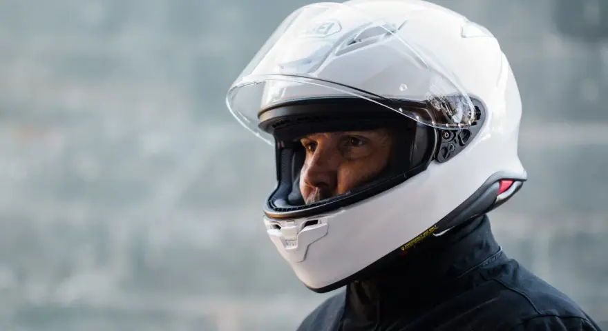 Hombre con casco blanco Shoei NXR 2. Su peso es ideal para largas rutas.