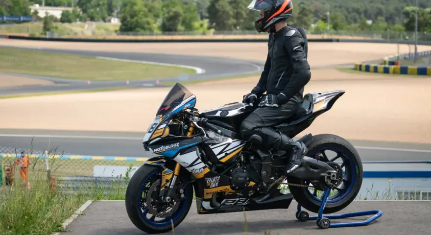 Piloto con talla mono moto listo para competir en circuito.
