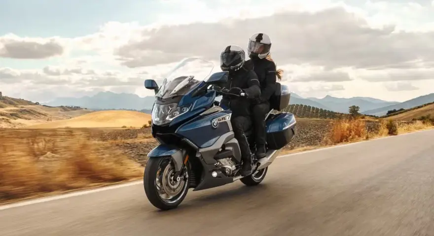 Pareja disfrutando de un viaje en moto cómoda por un paisaje rural.