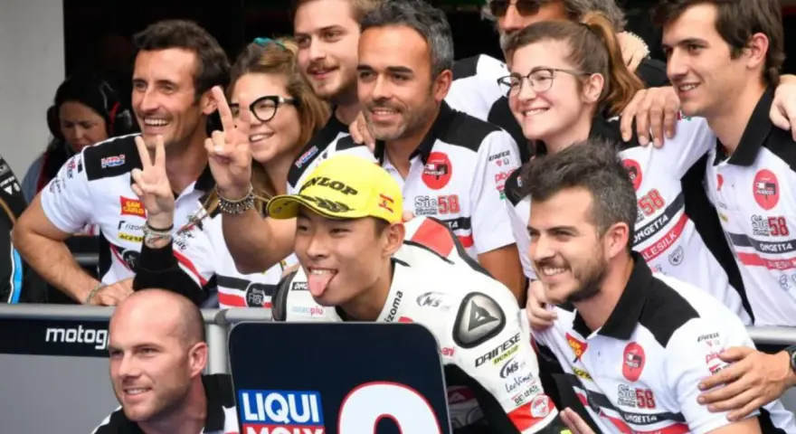 El equipo de Paolo Simoncelli celebra con gestos de victoria.