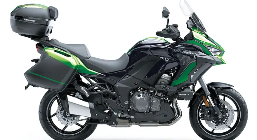 Una moto crossover Kawasaki Versys negra y verde, lista para la aventura con maletas laterales y baúl.