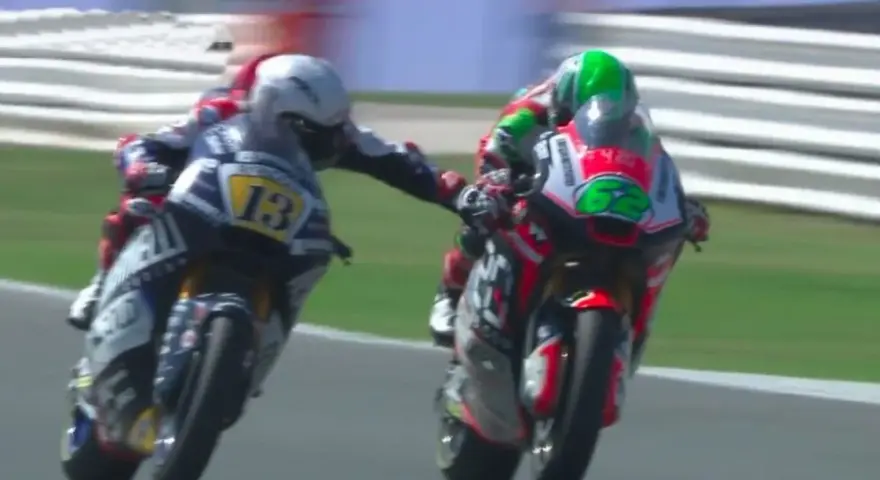 Dos pilotos de MotoGP compiten, uno con el número 13 y el otro con el 62. Romano Fenati, con el 13, intenta adelantar.