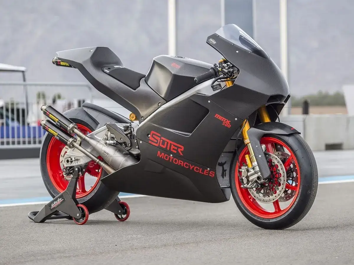 La Suter MMX 500, una moto de carreras de carbono negro con detalles rojos, lista para la pista.