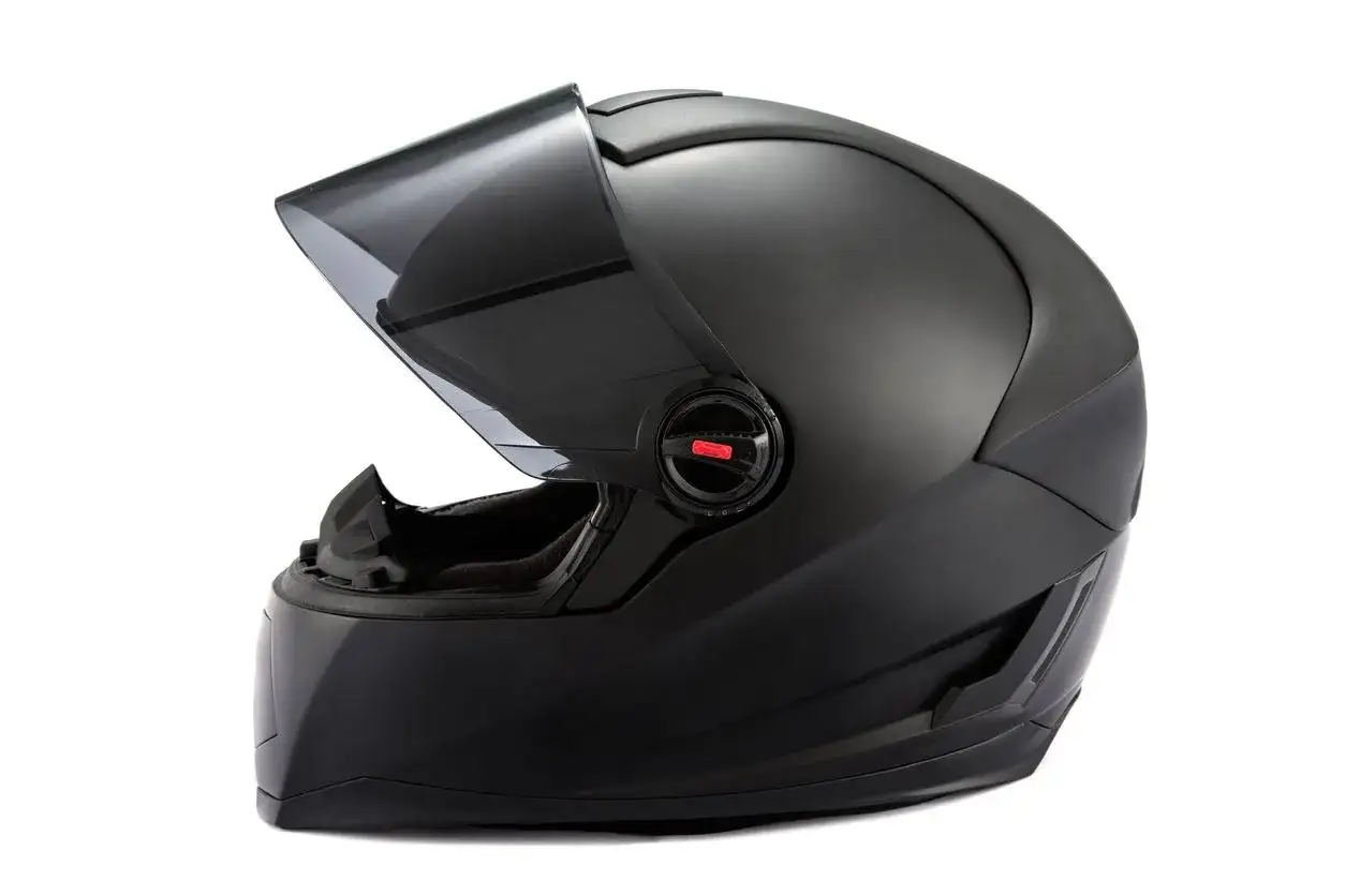 Casco negro mate con visor oscuro levantado, listo para la prueba de cascos.