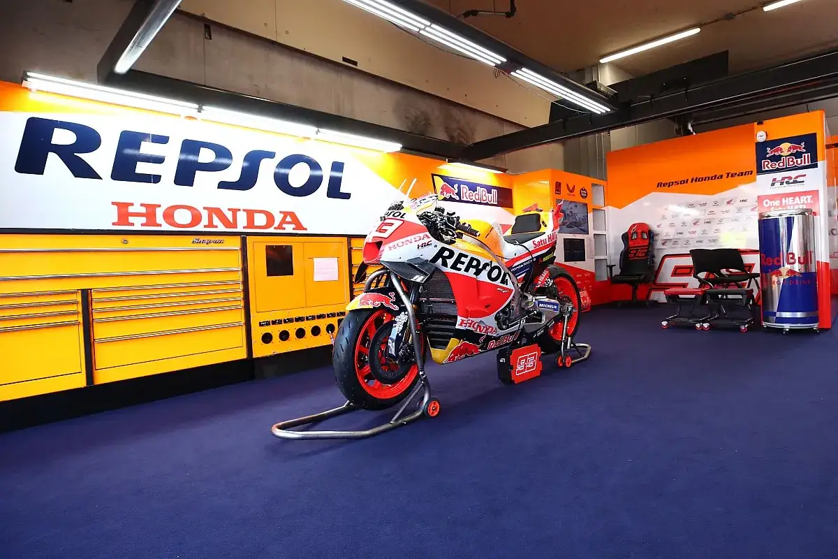 Moto de competici&oacute;n del Repsol Honda Team en boxes, lista para la acci&oacute;n.