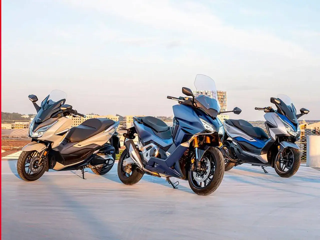 Tres scooters Honda Forza 125 colores: beige, azul oscuro y gris con azul. Listos para la aventura urbana.