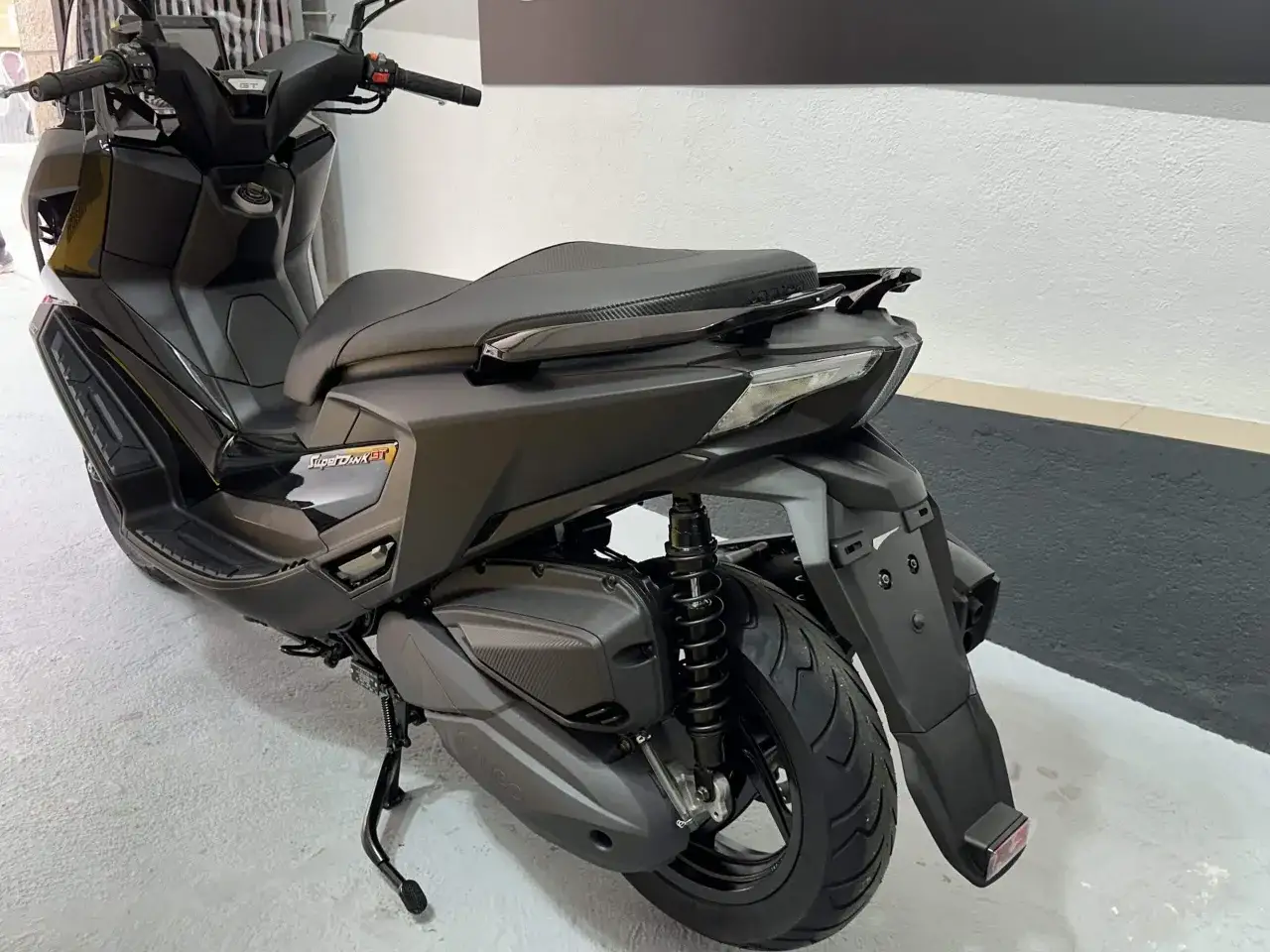 Vista trasera de una Kymco Super Dink 125 GT negra. Las opiniones sobre este modelo son muy positivas.
