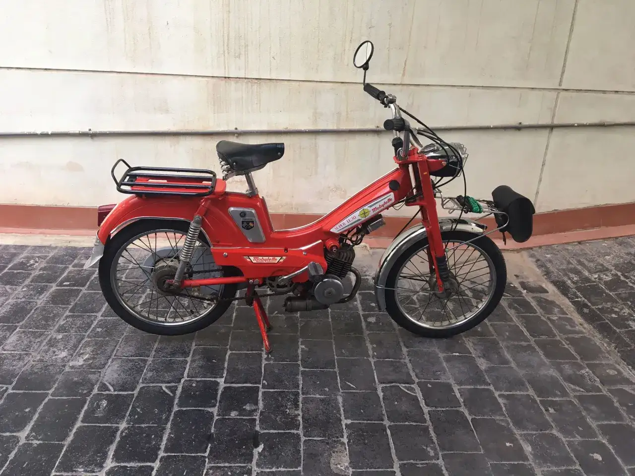 Ciclomotor Mobylette rojo, listo para matricular. Un clásico que evoca la libertad de antaño.