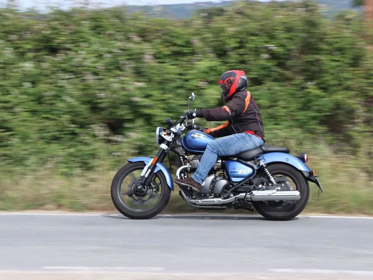 Motociclista en una Royal Enfield Super Meteor 650 azul, disfrutando de un paseo. Opiniones positivas sobre su rendimiento y estilo.
