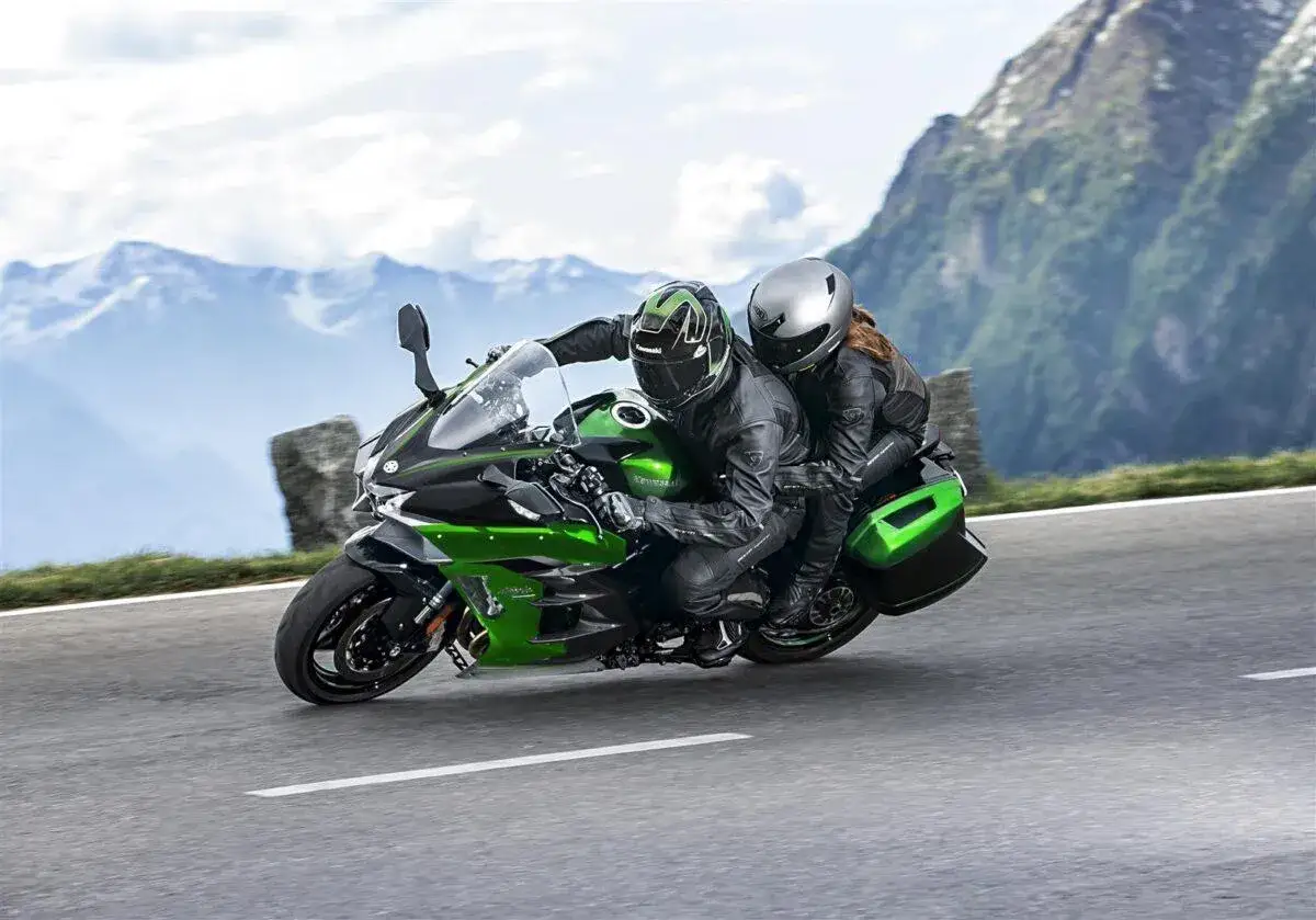 Pareja disfrutando de motos para viajar en pareja por carreteras monta&ntilde;osas.