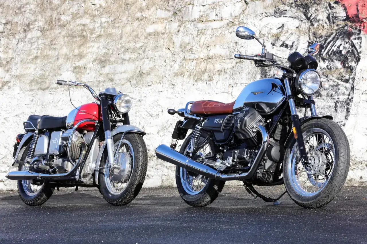 Dos motos cl&aacute;sicas Moto Guzzi V7, una roja y plateada, otra cromada y negra, listas para la carretera.