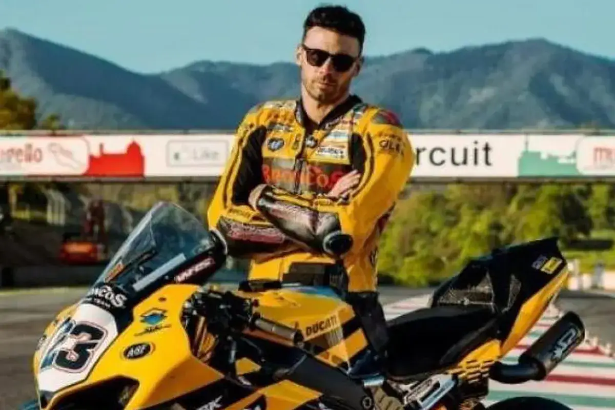 Romano Fenati, piloto de motociclismo, posa con su moto de carreras amarilla y negra en un circuito.