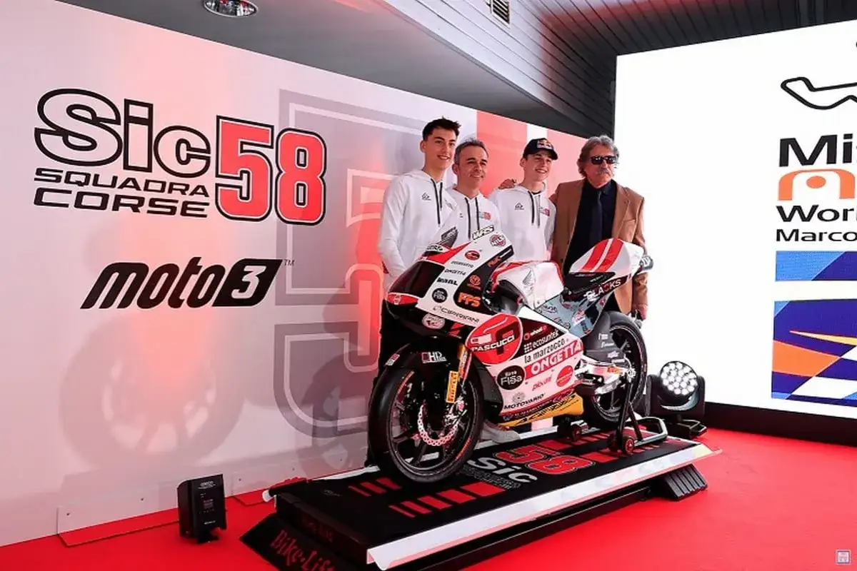 El equipo Sic58 Squadra Corse presenta su moto Moto3. Paolo Simoncelli, rodeado de jóvenes pilotos, sonríe ante la cámara.