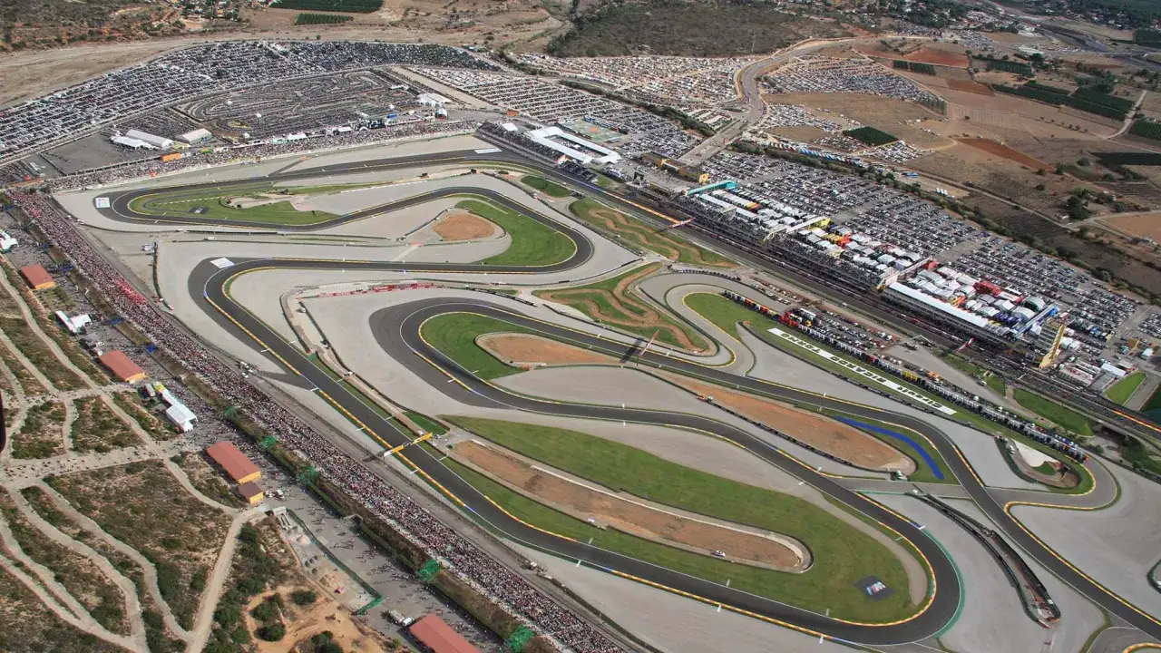 Vista aérea del aspar circuit, con gradas llenas y miles de coches aparcados.