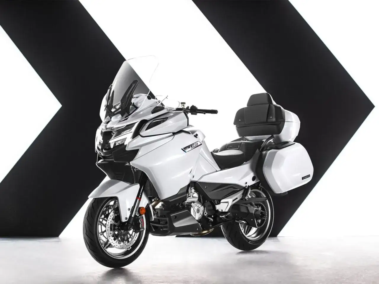 CFMoto 1250 TR-G blanca, lista para la aventura, con maletas y parabrisas alto.