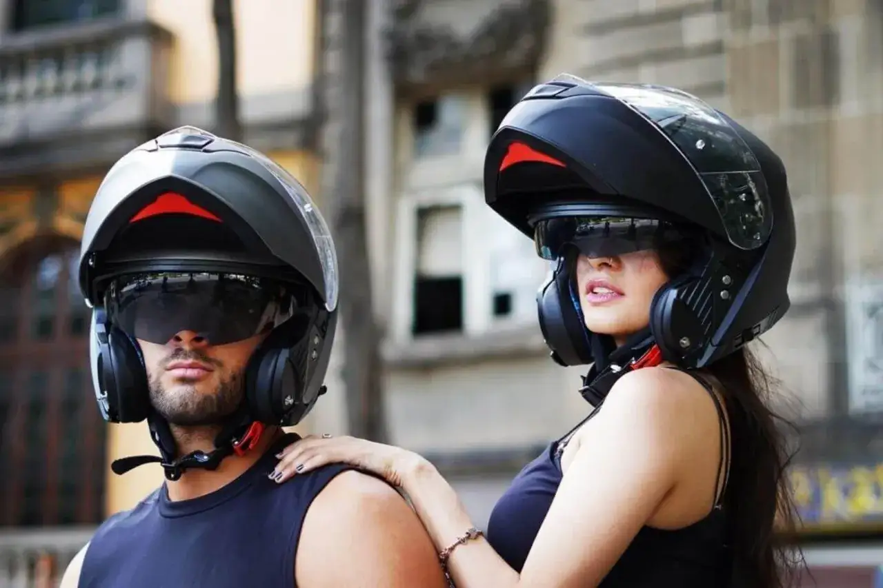 Pareja lista para rodar con su casco integral o modular, protegiendo sus rostros y visiones.
