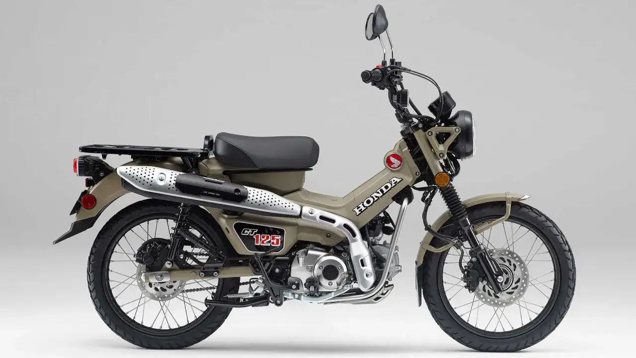 Honda CT 125, una moto todoterreno color arena con un diseño robusto y un portaequipajes trasero, lista para la aventura.