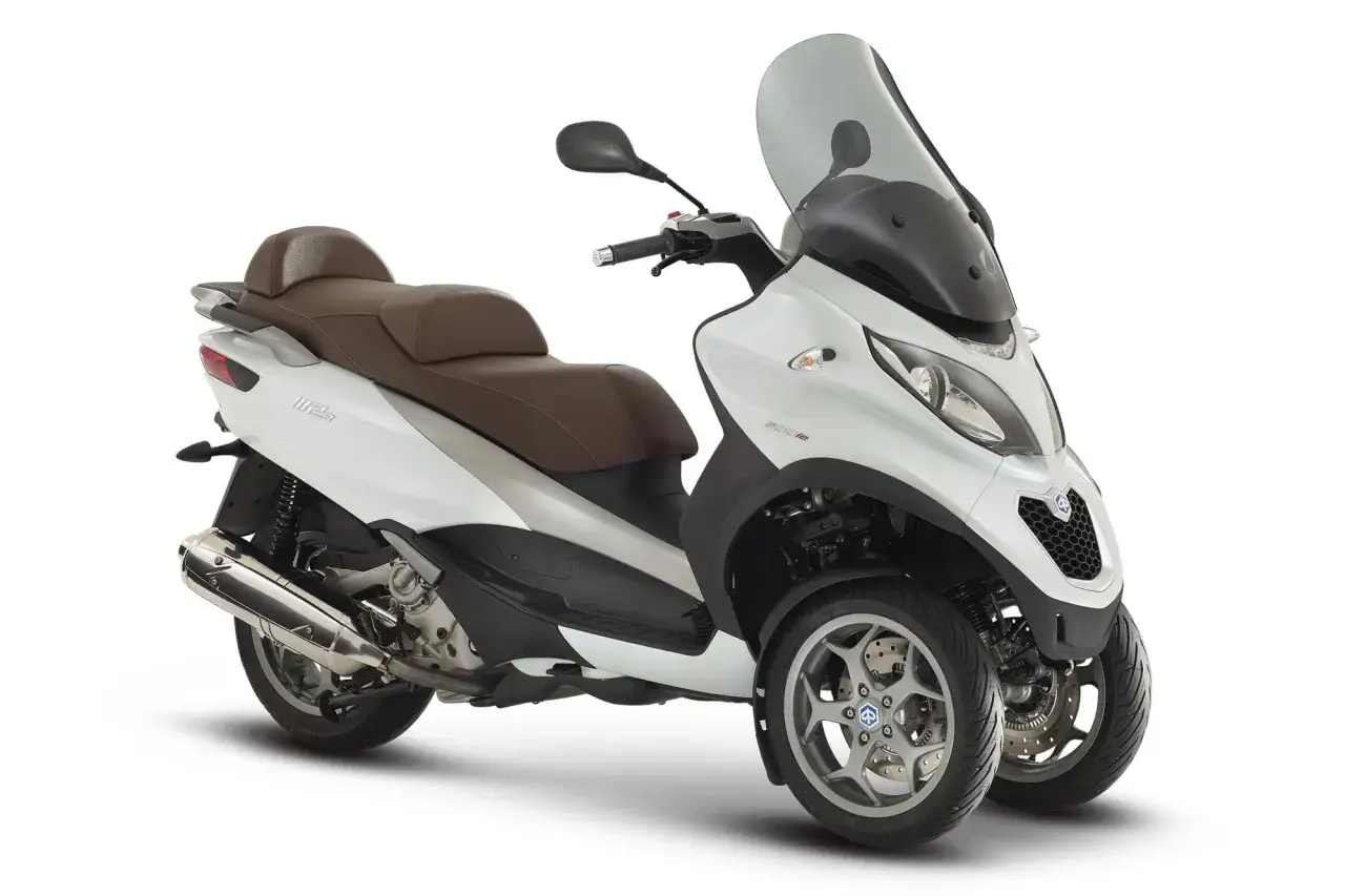 Elegante moto de tres ruedas blanca con asiento marrón y parabrisas ahumado, lista para la aventura.