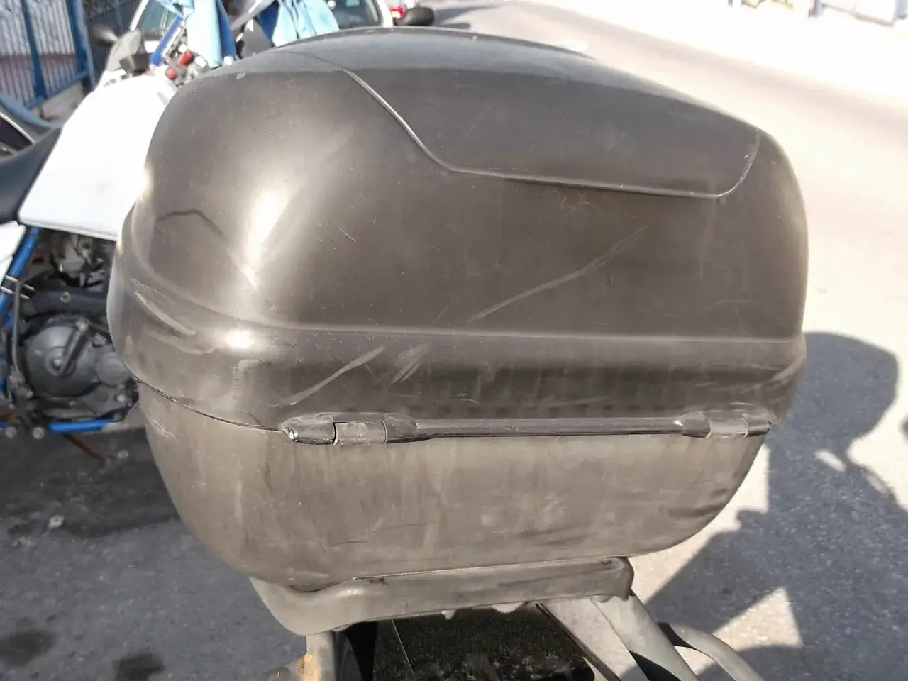 Baúl negro de moto con rayones, listo para pintar y darle un nuevo look.