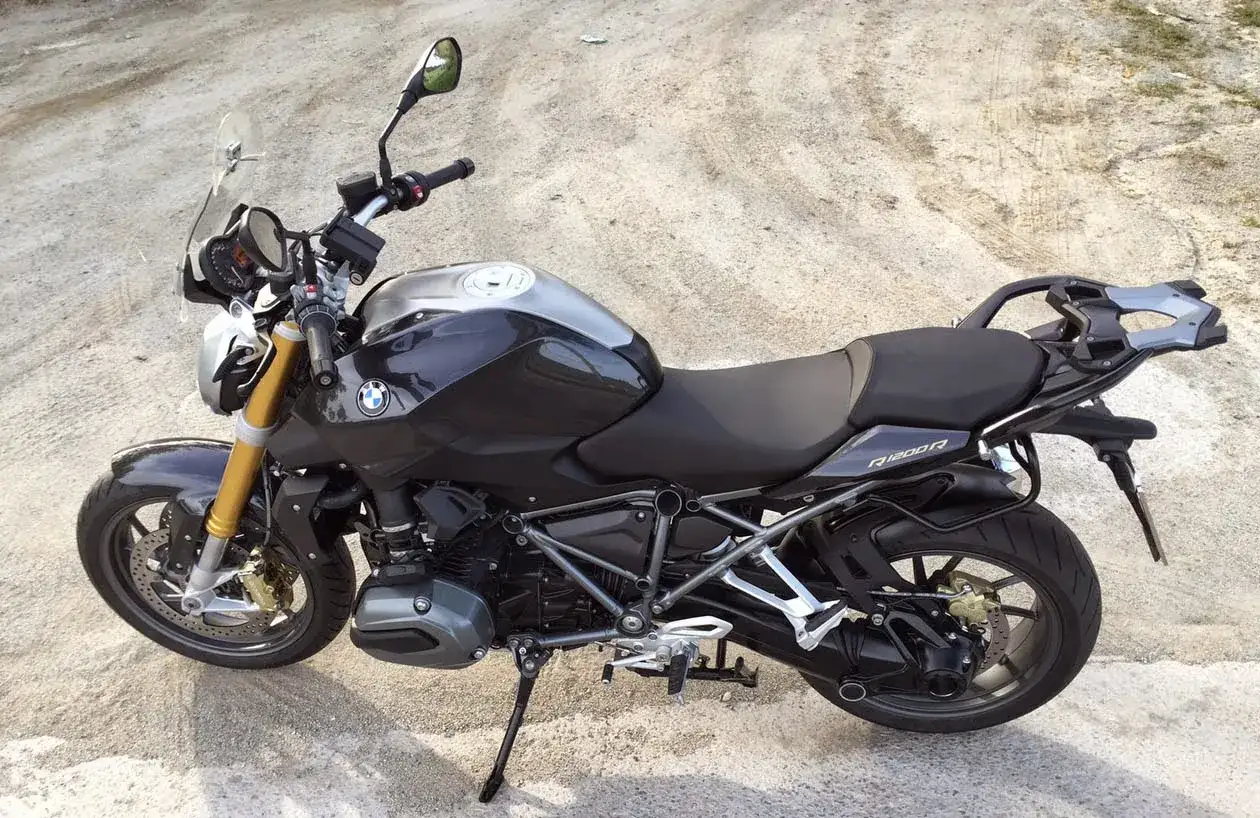 Detalle de la BMW R1200R, ideal para consultar su ficha técnica. Moto deportiva negra con detalles plateados y horquilla dorada.